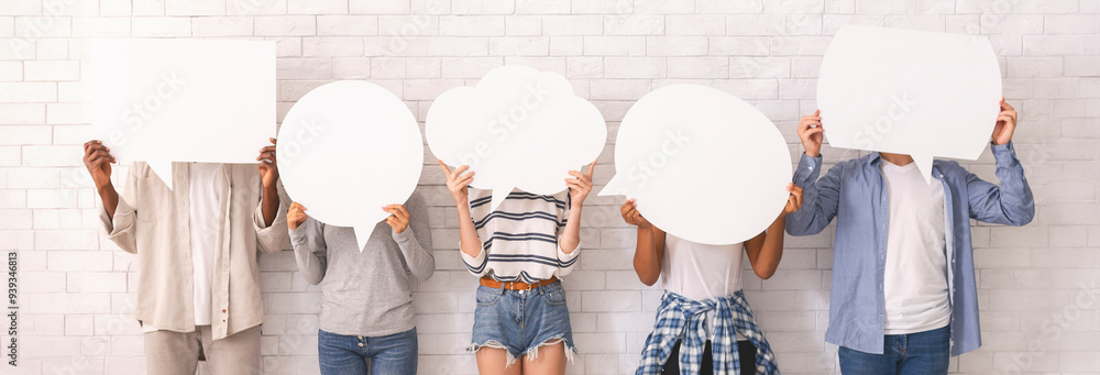 © Prostock-studio - Multiracial group of teenagers in casual clothes hiding behind speech bubbles, communication concept, white background