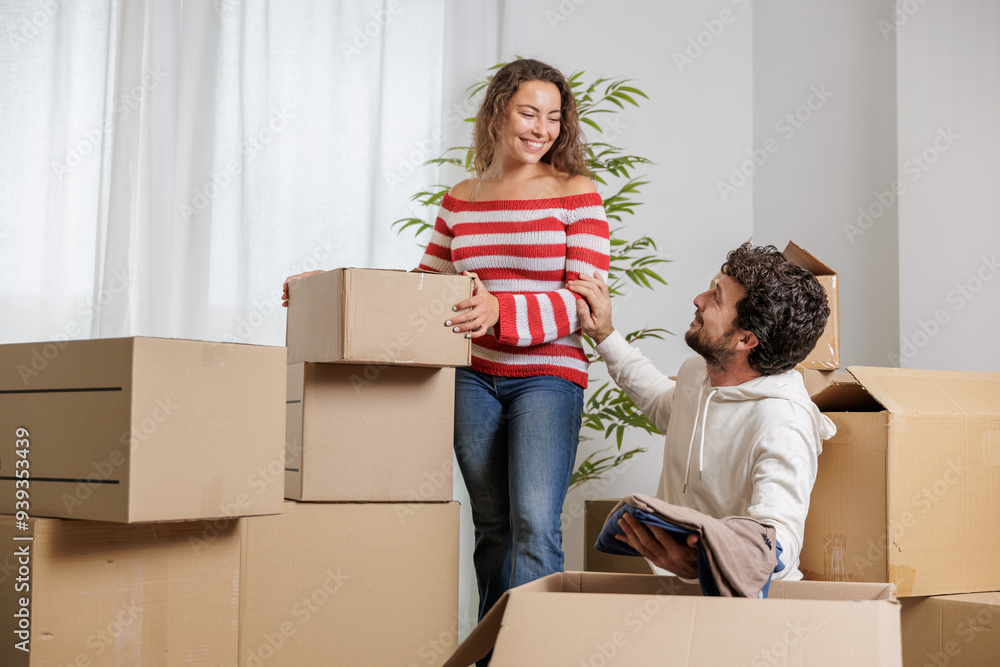 Excited young couple in their new house. They are unpacking their belongings for their new life. Real estate, home sales Excited young couple in their new house. They are unpacking their belongings for their new life. Real estate, home sales