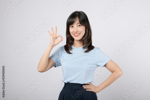 Smiling woman making an OK hand gesture, exuding confidence and positivity.