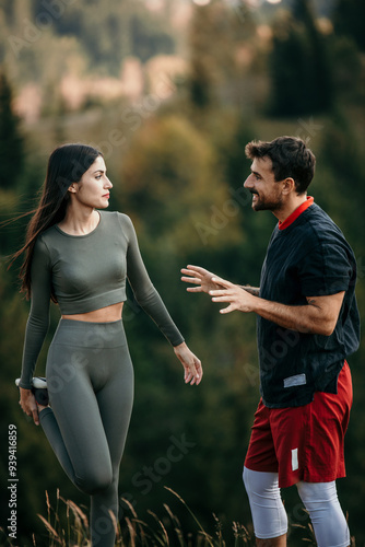 Shot of a young couple stretching while out for a workout on a mountain road