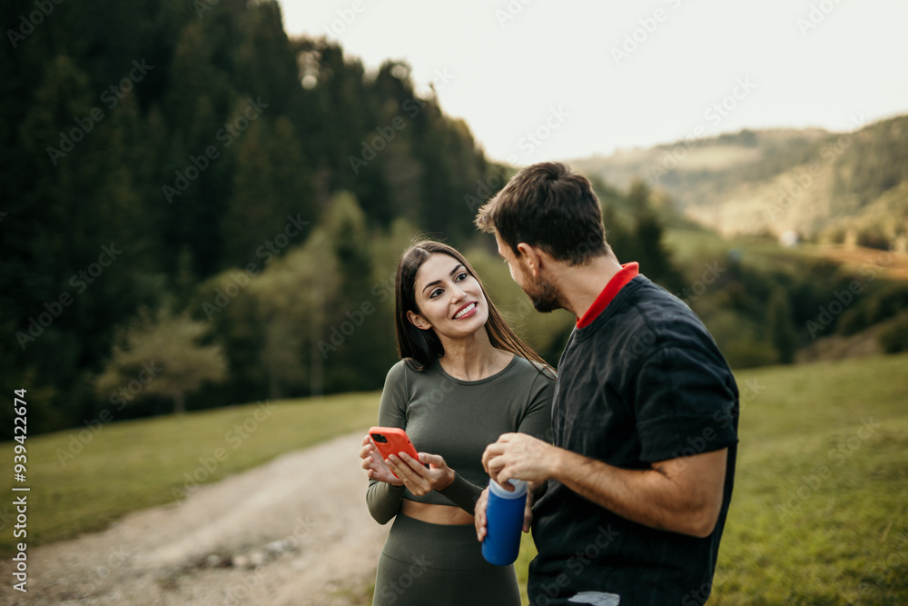 Cropped shot of two attractive young couple using a smartphone during a jog Cropped shot of two attractive young couple using a smartphone during a jog