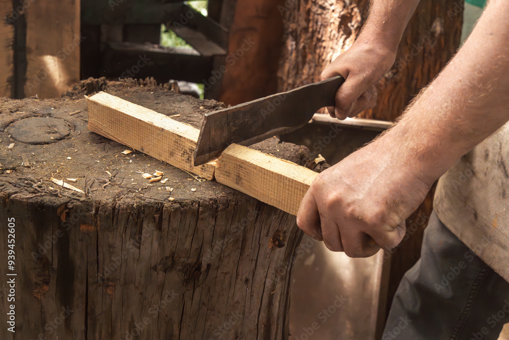 Man's hand cuts wooden slats with a metal cleaver. Close-up Man's hand cuts wooden slats with a metal cleaver. Close-up