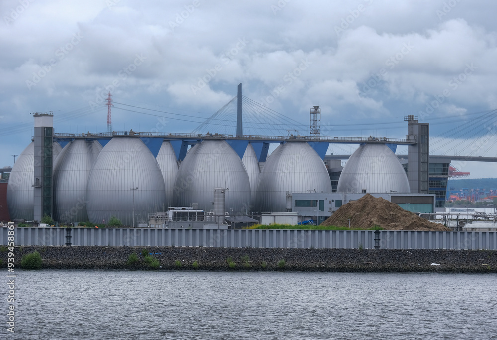 Kläranlage Hamburg: Nachhaltige Energieerzeugung und Abwasserbehandlung mit Blick auf die bekannten einförmigen Faultürme und Hafenlandschaft Kläranlage Hamburg: Nachhaltige Energieerzeugung und Abwasserbehandlung mit Blick auf die bekannten einförmigen Faultürme und Hafenlandschaft