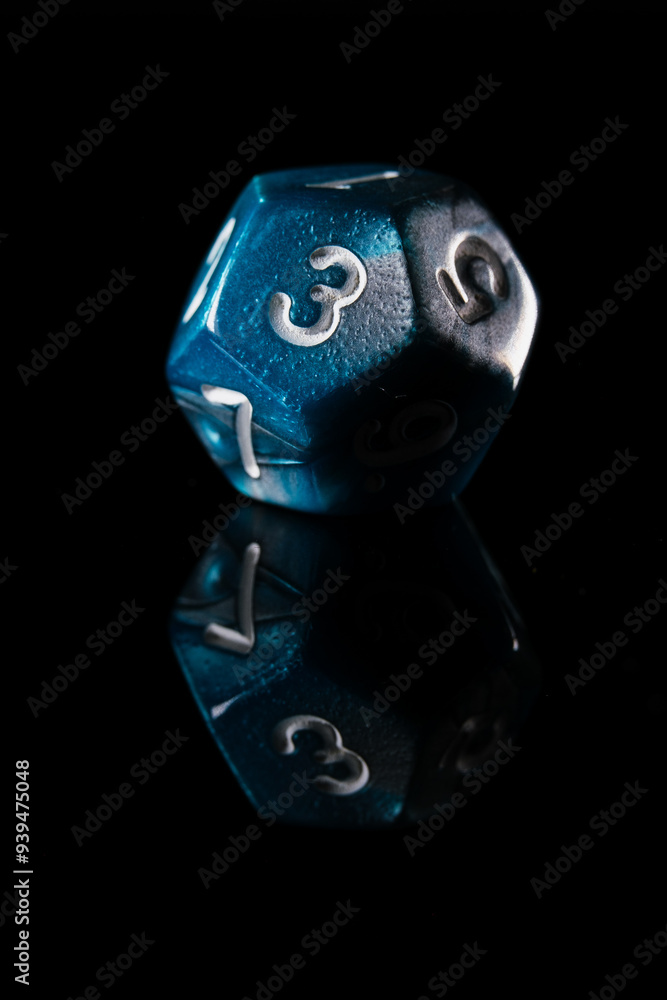 a two-toned blue twelve-sided D12 dice with white numbers showing the number three, on a black background with a reflection a two-toned blue twelve-sided D12 dice with white numbers showing the number three, on a black background with a reflection