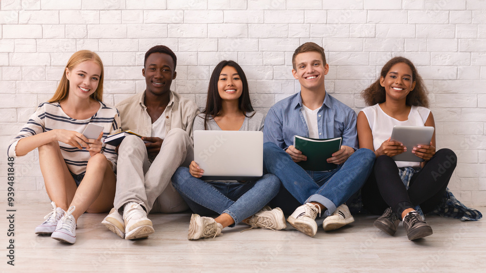 © Prostock-studio - Cheerful group of international students studying over white brick wall, using laptop, books, digital tablets, panorama © Prostock-studio - Cheerful group of international students studying over white brick wall, using laptop, books, digital tablets, panorama