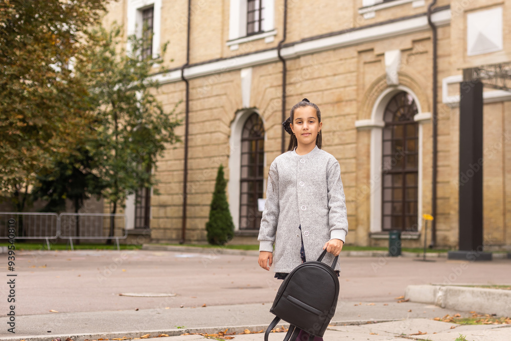 A young teenage girl goes to school with a backpack. A teenage student or a schoolgirl. The concept of education. A young teenage girl goes to school with a backpack. A teenage student or a schoolgirl. The concept of education.