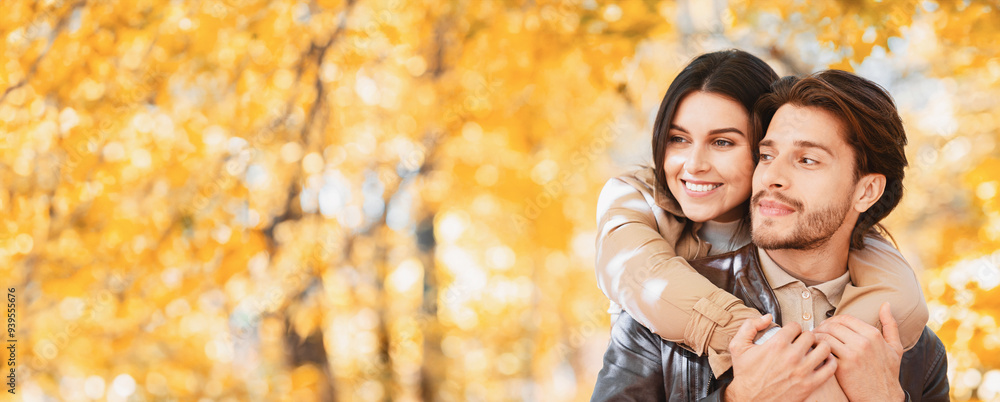 Woman in love hugging her handsome man from behind, one day at autumn forest, panorama with copy space Woman in love hugging her handsome man from behind, one day at autumn forest, panorama with copy space