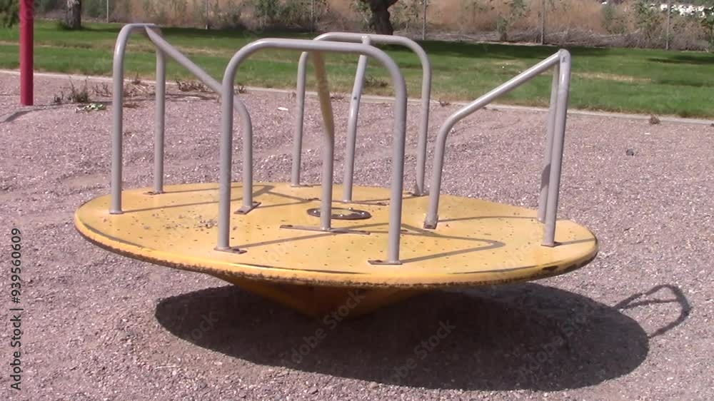 Old style yellow merry-go-round carousel slowly spinning to full stop