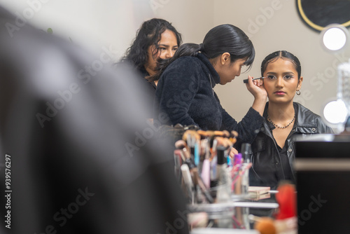 Make up artist applying eyeliner to a customer in a beauty salon photo