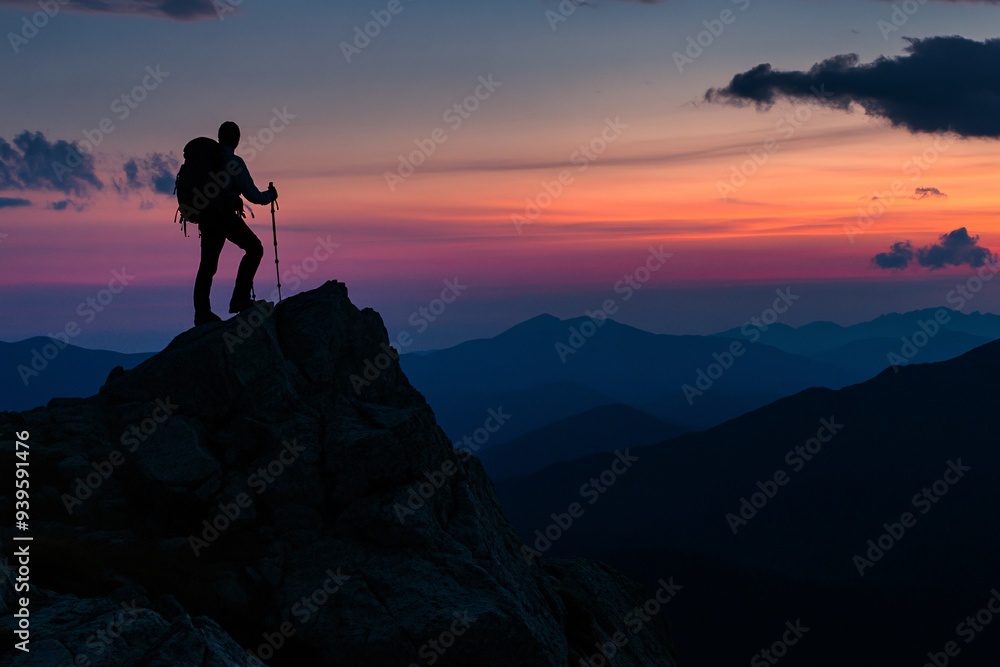 Fototapeta premium A man is standing on a mountain top with a backpack