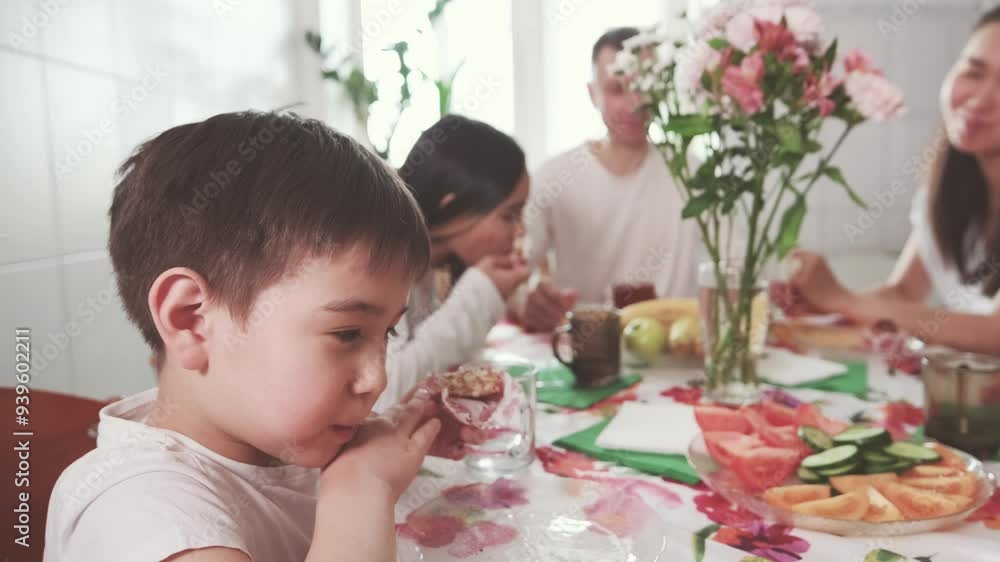 A family sits at the table early in the morning and enjoys breakfast together A family sits at the table early in the morning and enjoys breakfast together
