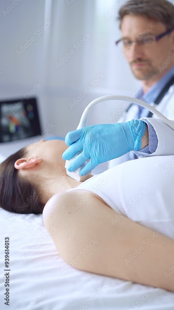 Fototapeta premium Doctor man wearing blue protective gloves is using ultrasound equipment on the neck of a patient woman, lying for examination. Medicine concept
