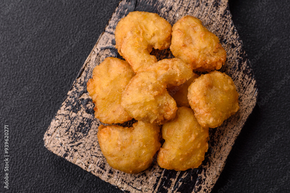 Delicious fresh crispy chicken nuggets on a dark concrete background Delicious fresh crispy chicken nuggets on a dark concrete background