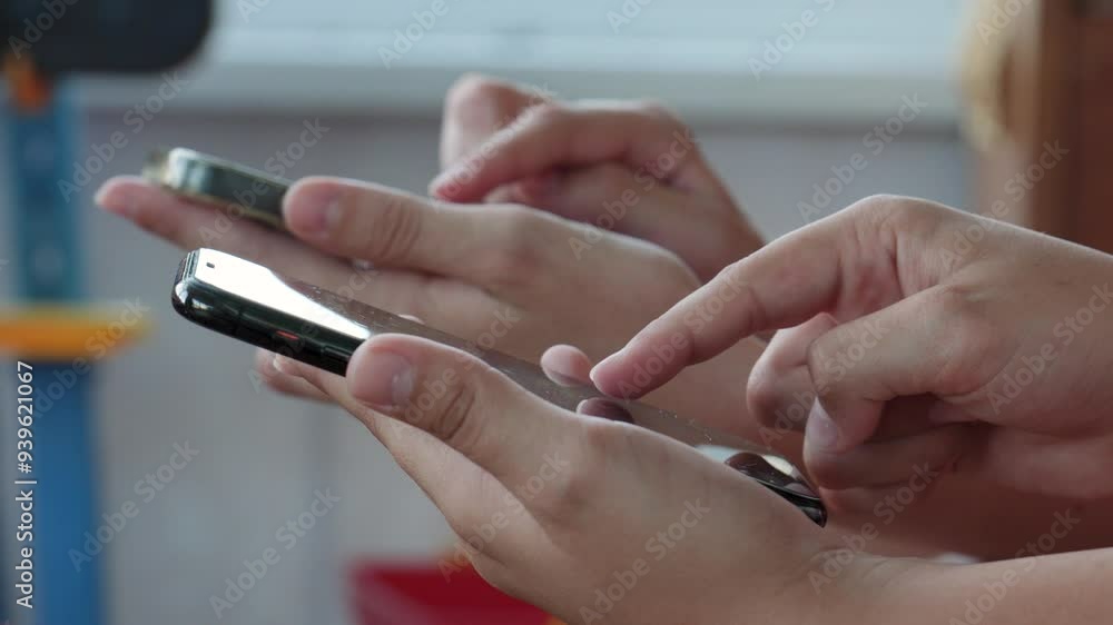 Childs quickly taps his fingers on smartphone screen to earn cryptocurrency in online application. Play games on smartphone. Brother and sister together play tap swap game Childs quickly taps his fingers on smartphone screen to earn cryptocurrency in online application. Play games on smartphone. Brother and sister together play tap swap game