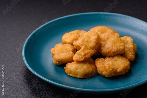 Delicious fresh crispy chicken nuggets on a dark concrete background