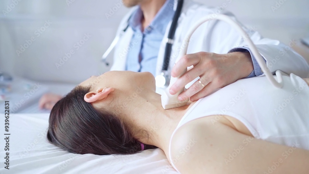 Doctor man is using ultrasound equipment on neck of female patient lying down for a medical examination. Medicine and science Doctor man is using ultrasound equipment on neck of female patient lying down for a medical examination. Medicine and science