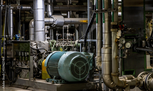 Schilderij op canvas A large motor and pump connected to a maze of large diameter industrial piping