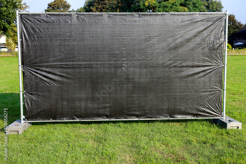 Blinded fence with concrete bases; iron fencing; construction barrier; pre-galvanized construction fence; construction fence base. photo