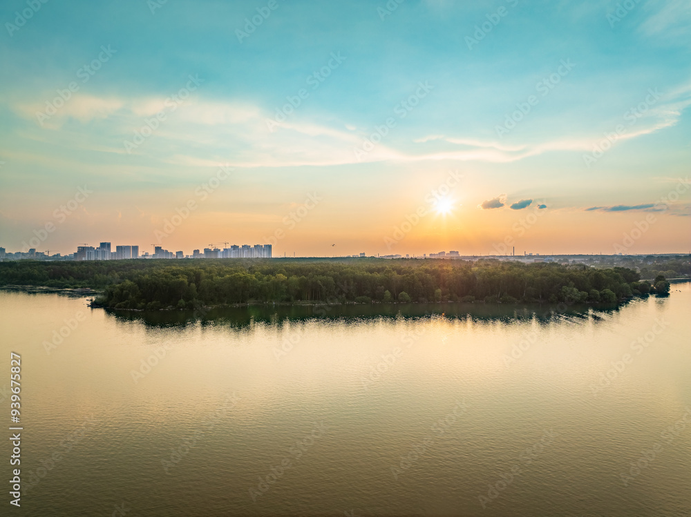 Big lake with green shores in bright sun light and city on horizon, aerial landscape. Recreation concept. Aerial view Big lake with green shores in bright sun light and city on horizon, aerial landscape. Recreation concept. Aerial view