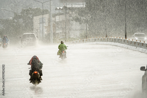 Photography A group of motorcyclists ride down a wet road in the rain