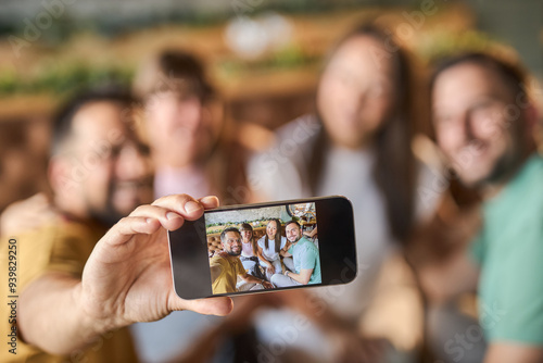 Close up of happy couples  having fun while taking a selfie with mobile phone in a cafe photo