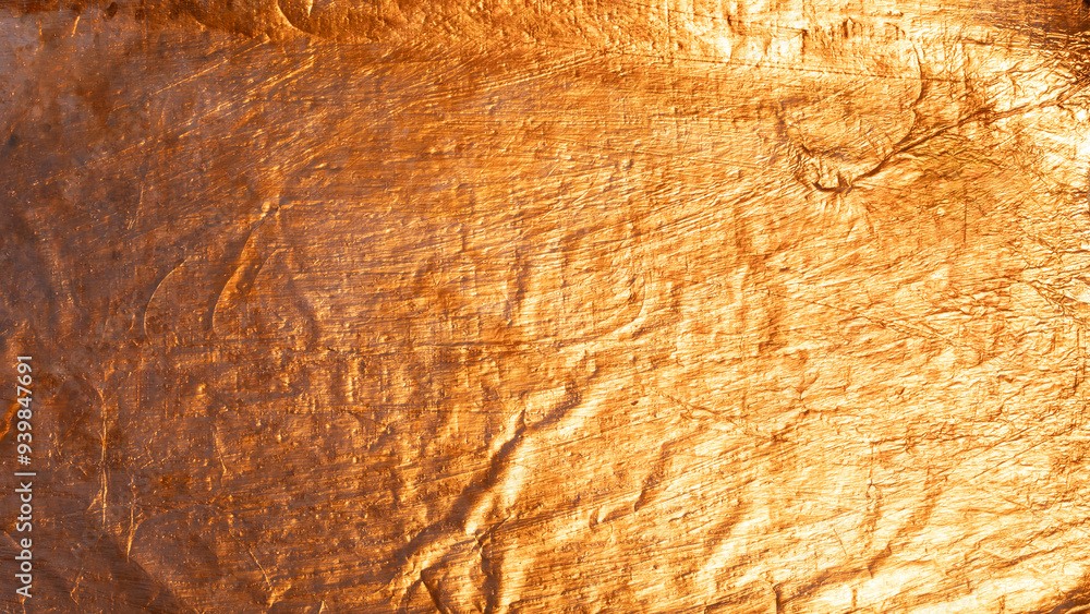 Naklejka premium Abstract background created by crumpled shiny golden metallic texture