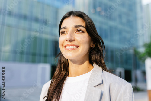 Young empowered businesswoman standing over company building office. Entrepreneur vision and business empowerment concept.