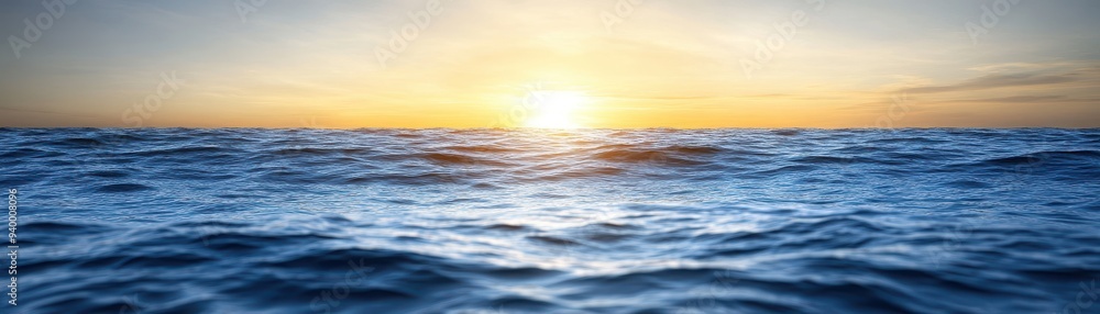 Obraz premium A serene sunset over calm ocean waters, reflecting warm hues of orange and yellow. Perfect for nature and relaxation themes.