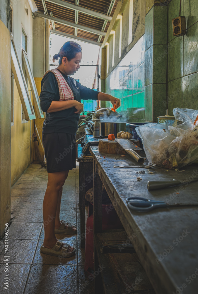 a woman is tossing the chopped carrots into the boiling pot a woman is tossing the chopped carrots into the boiling pot