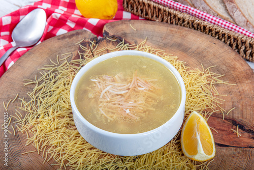 Traditional Turkish Cuisine Homemade chicken soup prepared with vermicelli (noodles) and vegetables in a white bowl. Turkish name; Tel sehriye corbasi. photo