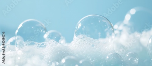 Macro shot of white soap foam bubbles spread across a blue background, highlighting the texture and details of the bubbles in a fresh and clean setting.
