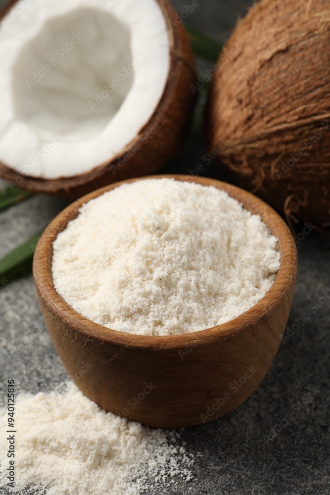 Organic coconut flour in bowl and fresh fruits on grey table, closeup Organic coconut flour in bowl and fresh fruits on grey table, closeup