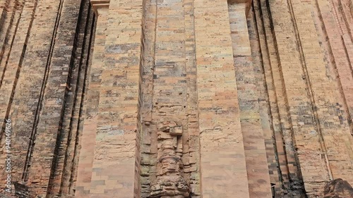 Panning shot of PoNagar Cham towers complex. This is an ancient Hindu temple in Nha Trang city, Vietnam. Close up brick wall of temple. photo