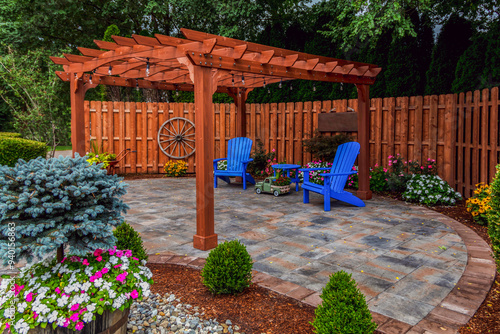 Wooden pergola on pavers landscape design with select ornamental flowers and evergreens backyard oasis