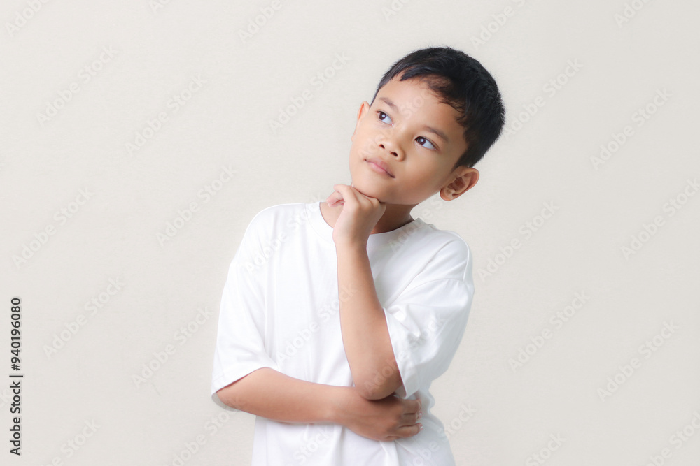 Thinking a cute little asian boy on white background. Child thinking. Education concept. Brainstorming and idea concept. Thinking a cute little asian boy on white background. Child thinking. Education concept. Brainstorming and idea concept.