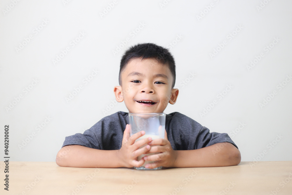 Asian child drinking milk on white background. Smiling of Asian boy with a glass of milk. Asian child drinking milk on white background. Smiling of Asian boy with a glass of milk.
