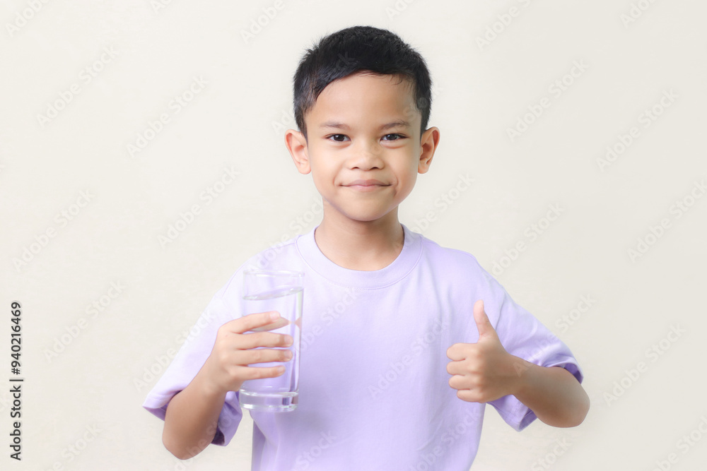 cute little asian boy Standing and Smiling little with a holding an empty glass of water on white background. cute little asian boy Standing and Smiling little with a holding an empty glass of water on white background.