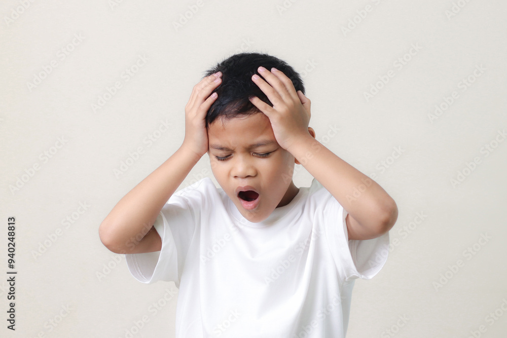 Frustrated little asian boy suffers from headache, keeps hands on temples, isolated on white background. Frustrated little asian boy suffers from headache, keeps hands on temples, isolated on white background.