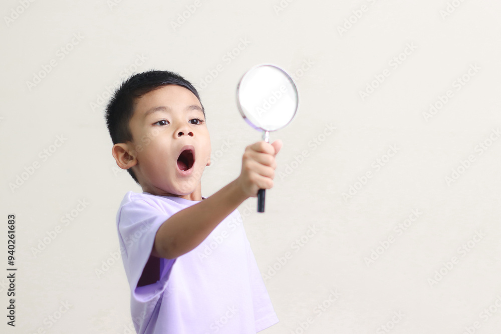 Portrait of surprised cute little asian boy looking through a magnifying glass. Education concept. Portrait of surprised cute little asian boy looking through a magnifying glass. Education concept.