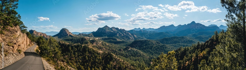 Winding Road Through Mountainous Landscape With Blue Sky And Clouds Winding Road Through Mountainous Landscape With Blue Sky And Clouds