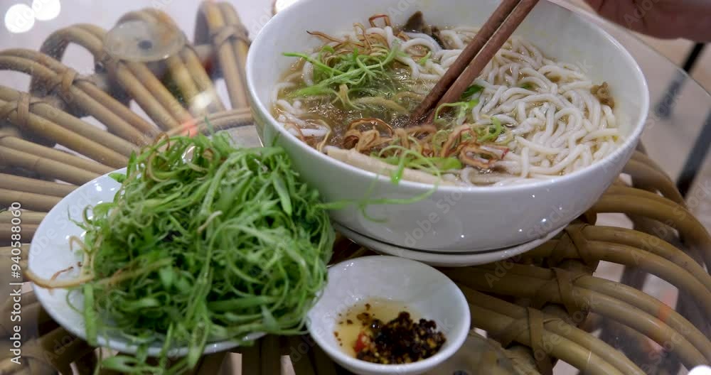 Vietnamese soup pho girl's hand takes rice noodles with chopsticks eat delicious traditional food. Traditional Vietnamese beef soup pho Vietnamese soup pho girl's hand takes rice noodles with chopsticks eat delicious traditional food. Traditional Vietnamese beef soup pho