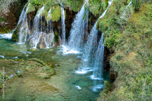 Nature and landscape. Waterfalls in the forest flowing into lakes. Tourists visit famous Plitvice park in Croatia. Mountain streams with clear water. Waterfalls of Plitvice Lakes on a summer day.