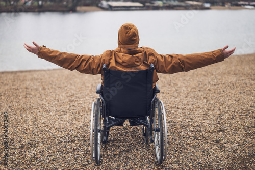 Φωτογραφία Rear view image of paraplegic handicapped man in wheelchair by the lake