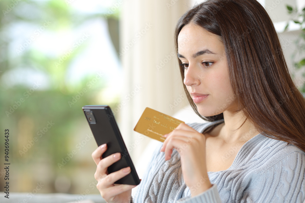 Serious woman buying online in a house Serious woman buying online in a house