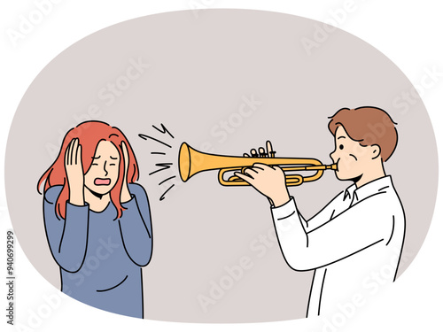 Man plays trumpet near woman covering ears, for concept trumpeter lack musical talent. Guy who wants to become professional musician learns to play compositions on trumpet and interferes with others