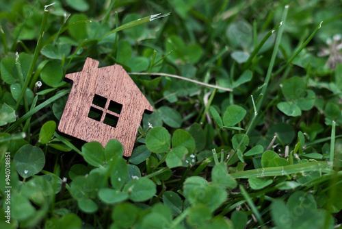 Obraz na płótnie Little wood home model on green nature background. Eco friendly home concept. w salonie
