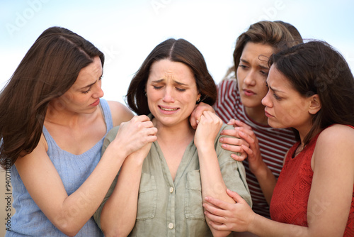 Group of friends comforting a sad woman photo