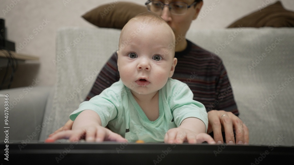 Father and baby son joyfully playing the piano together Father and baby son joyfully playing the piano together