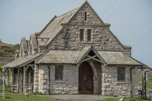 Great Orme Cemetery Chapel, Llandudno, a pretty stone-built medieval church standing amongst many grave stones in a cemetery