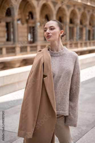 Young beautiful woman wearing coat walking in the city centre of Prague, Europe photo